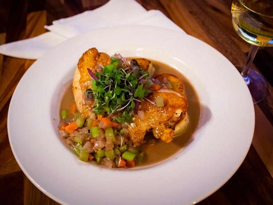 The Bistro's Coq au vin features a split roasted chicken, mirepoix (onions, carrots, and celery), and fondant potato in a Jeunette Rouge reduction ($32)