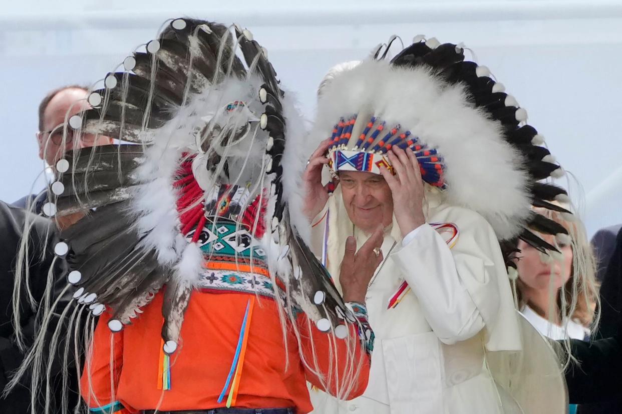 Pope Francis puts on an indigenous headdress during a meeting with indigenous communities, including First Nations, Metis and Inuit, at Our Lady of Seven Sorrows Catholic Church in Maskwacis, near Edmonton, Canada, Monday, July 25, 2022. Pope Francis begins a "penitential" visit to Canada to beg forgiveness from survivors of the country's residential schools, where Catholic missionaries contributed to the "cultural genocide" of generations of Indigenous children by trying to stamp out their languages, cultures and traditions. Francis set to visit the cemetery at the former residential school in Maskwacis. 