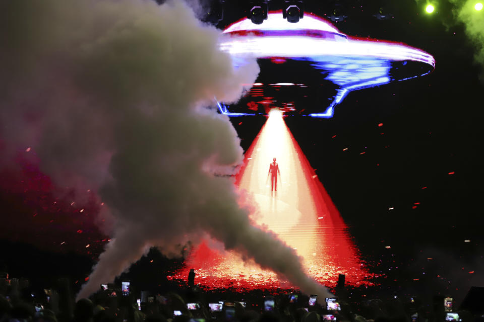 An avatar of El Salvador's President Nayib Bukele, is projected on a LED screen descending from a flying saucer during the closing ceremony of a congress for cryptocurrency investors in Santa Maria Mizata, El Salvador, Saturday, Nov. 20, 2021. Bukele announced during the rock concert-like atmosphere at the gathering that his government will build an oceanside "Bitcoin City" at the base of a volcano. (AP Photo/Salvador Melendez)