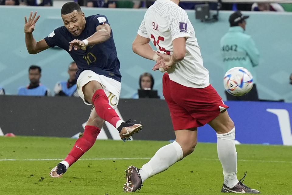 France's Kylian Mbappe, left, scores his side's second goal during the World Cup round of 16 soccer match between France and Poland, at the Al Thumama Stadium in Doha, Qatar, Sunday, Dec. 4, 2022. (AP Photo/Ricardo Mazalan)