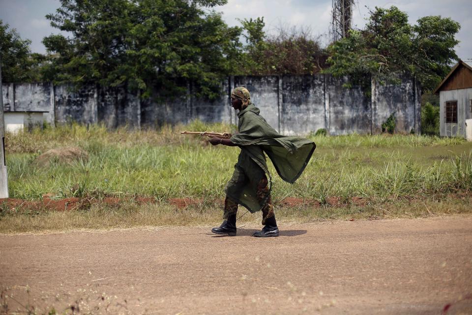 A Central African Army Forces (FACA) cadet walks with his fake gun in Jean Bedel Bocassa's Berengo palace near Pissa, some 80kms (45 miles) south west of Bangui, Central African Republic, Sunday Jan. 26, 2014. Up to 500 registered cadets are stationed in the palace turned training camp, without any officers, hunting mice and birds for food, using wood fake weapons and awaiting instructions that do not come. In Mbaiki, down the road, a local commander of the Muslim Seleka blamed Christian anti Balaka militias for sending the country into chaos and vowed reprisals if the newly appointed interim government would not put an end to Muslim killings in the country. (AP Photo/Jerome Delay)