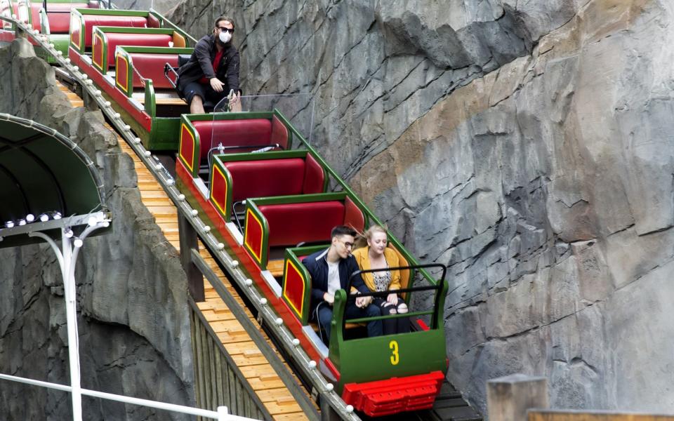 Guests sit on a roller coaster at Tivoli - GETTY IMAGES