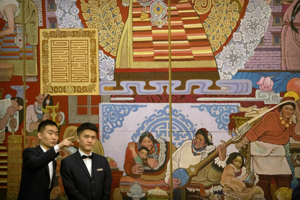 Attendants gesture as they prepare before a group discussion session held on the sidelines of the annual meeting of China's National People's Congress (NPC) in the Tibet Hall of the Great Hall of the People in Beijing, Wednesday, March 6, 2019. The Chinese Communist Party chief for Tibet said on Wednesday that the Dalai Lama has not done a "single good thing" for the region. (AP Photo/Mark Schiefelbein)