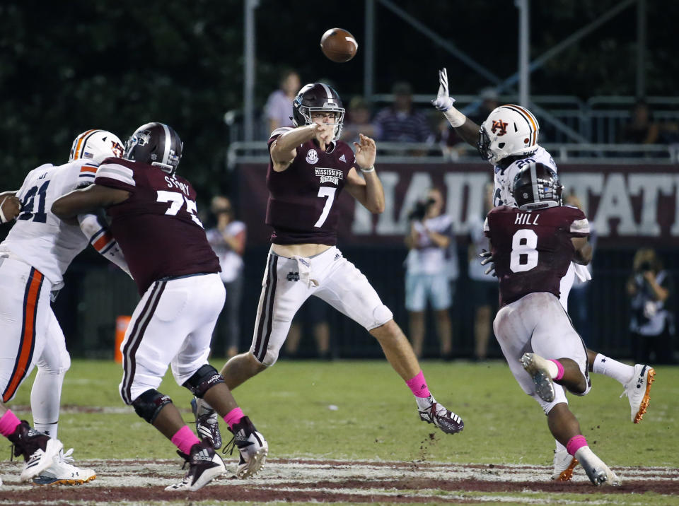 Mississippi State quarterback Nick Fitzgerald (7) leaps into the air as he passes under pressure by an Auburn player during the second half of their NCAA college football game in Starkville, Miss., Saturday, Oct. 6, 2018. Mississippi State won 23-9. (AP Photo/Rogelio V. Solis)