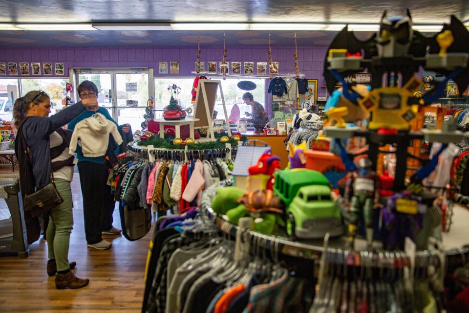 Director of Operations Jeanne Kinsella, second from left, assists a customer on Wednesday, Nov. 16, 2022, at Tutti Bambini ChildrenÕs Store. The nonprofit sells gently used children's clothing, toys and more, with proceeds benefiting local and border-area outreach programs for children. Donations of items to sell and cash donations are welcome; especially needed are children's clothes, sizes 2T and up.