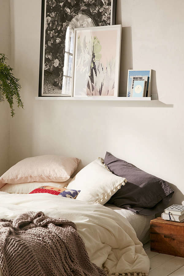 If you want the look of curated artwork with the versatility of being able to swap out pieces as your tastes change, <a href="https://www.urbanoutfitters.com/shop/wall-art-ledge" target="_blank">a picture ledge is a great option</a>. Most are designed with a small groove in the bottom that'll keep pictures at the same angle, and the upturned ledge will prevent them from falling.&nbsp;