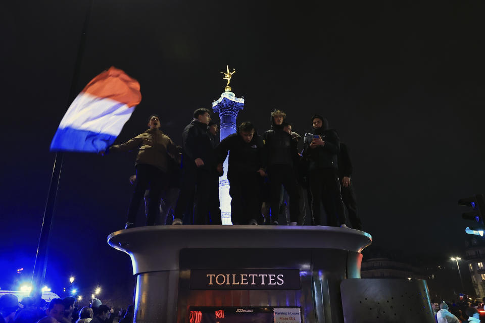 Supporters of France react in Bastille square at the end of the 2-0 victory of the World Cup semifinal soccer match between France and Morocco, in Paris, Wednesday, Dec. 14, 2022. (AP Photo/Aurelien Morissard)