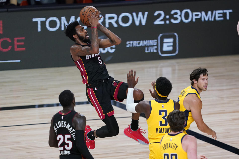 Miami Heat's Derrick Jones Jr. (5) shoots as Indiana Pacers' Aaron Holiday (3) defends during the first half of an NBA basketball game Monday, Aug. 3, 2020, in Lake Buena Vista, Fla. (AP Photo/Ashley Landis, Pool)