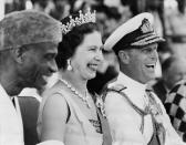 Queen Elizabeth II and Prince Philip smile as they watch the Susu dancers during their visit at the Northern Province of Sierra Leone. (STRINGER/AFP via Getty Images)