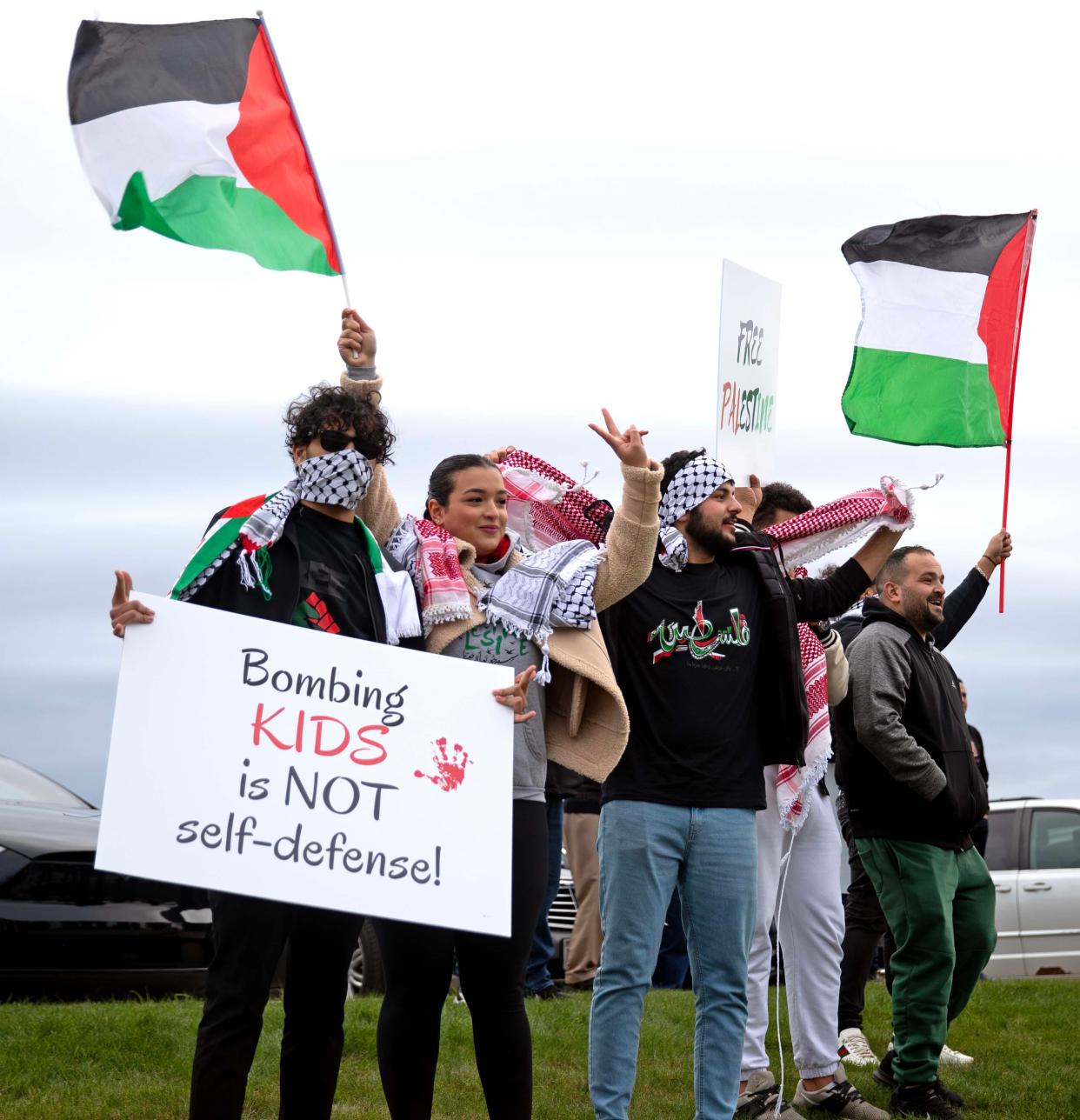 People hold up signs and flags to show their support for Palestinians impacted by Saturday's bombing in Gaza on Tuesday, Oct. 10, 2023, at the Islamic Society of Milwaukee.