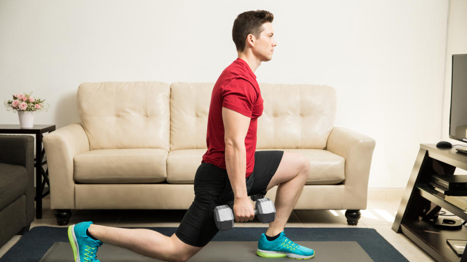 A man performing a dumbbell reverse lunge