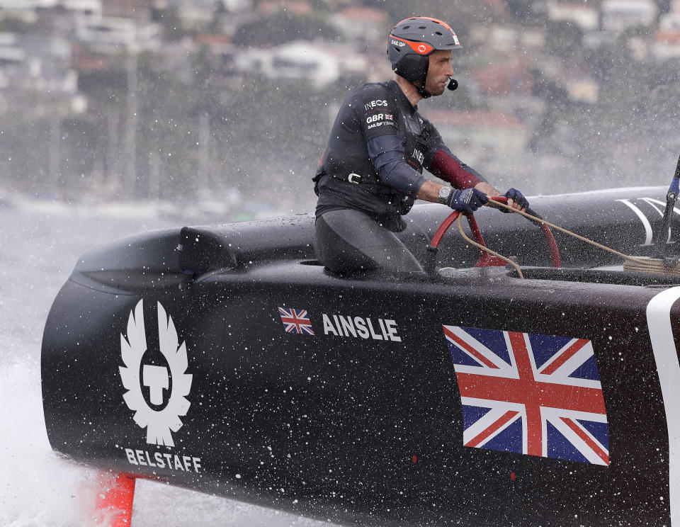 FILE - In this Feb. 29, 2020, file photo, skipper Ben Ainslie steers the boat as the British team slows after crossing the finish line in the second fleet race of the SailGP series in Sydney. Britain beat Australia in the final match race. The second regatta in SailGP’s second season will be notable for who’s missing as much as who will be sailing in Taranto, Italy.The biggest absence will be that of Ainslie, who helmed the British team to victory in the podium race in the opening regatta in Bermuda after Tom Slingsby’s defending champion Australian team dominated the fleet racing. (AP Photo/Rick Rycroft, File)