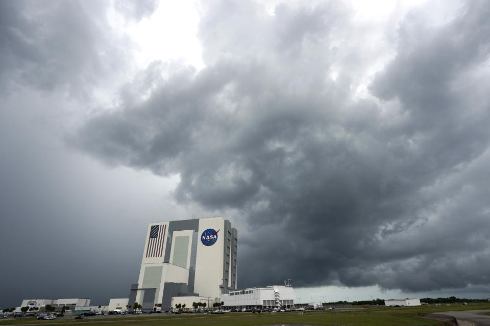 Storm clouds pass over the Vehicle Assembly Building as the SpaceX Falcon 9, with the Crew Dragon spacecraft on top of the rocket, sits on Launch Pad 39-A Wednesday, May 27, 2020, at Kennedy Space Center in Cape Canaveral, Fla. Two astronauts will fly on the SpaceX Demo-2 mission to the International Space Station scheduled for launch Wednesday afternoon. (AP Photo/David J. Phillip)