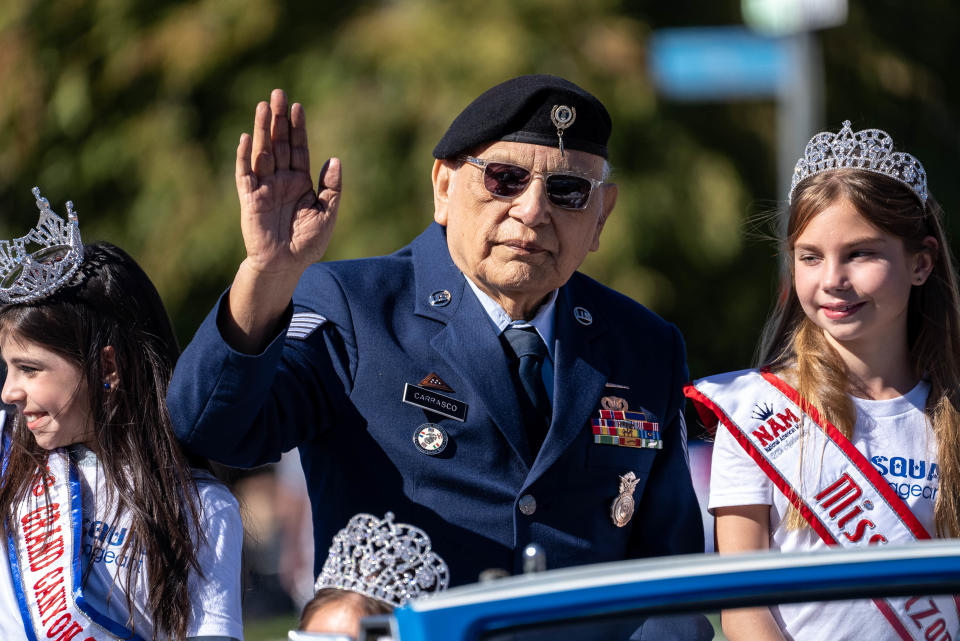 David Carrasco, a U.S. Air Force and Vietnam War veteran, waves during a Veterans Day parade in Phoenix on Nov. 11, 2022.