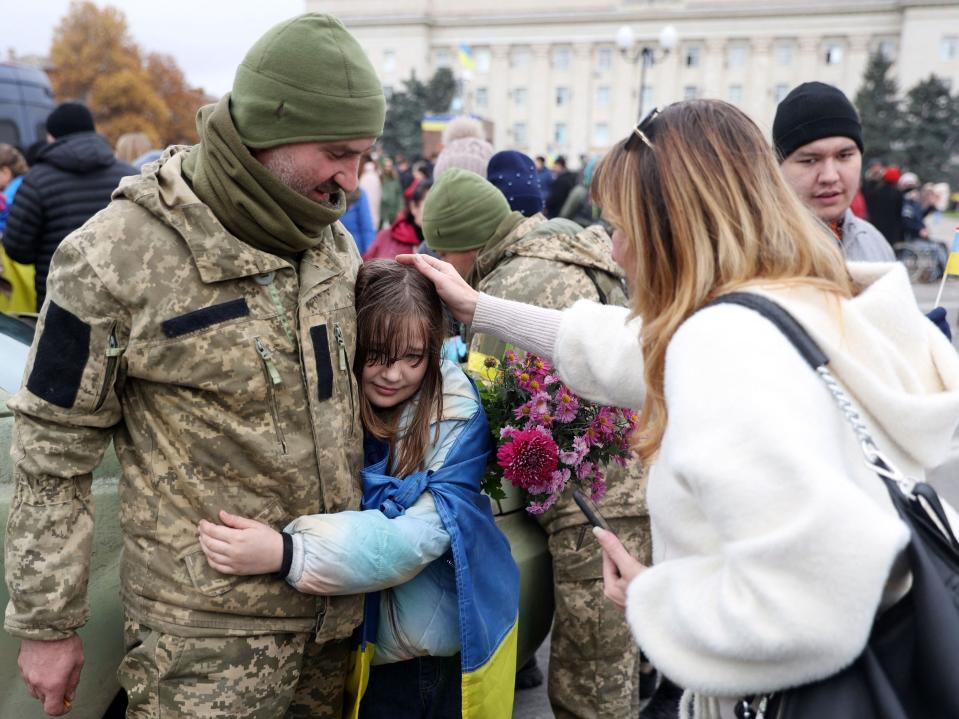 A girl hugs a Ukrainian soldier as local residents celebrate the liberation of their town in Kherson, on November 13, 2022, amid Russia's invasion of Ukraine.