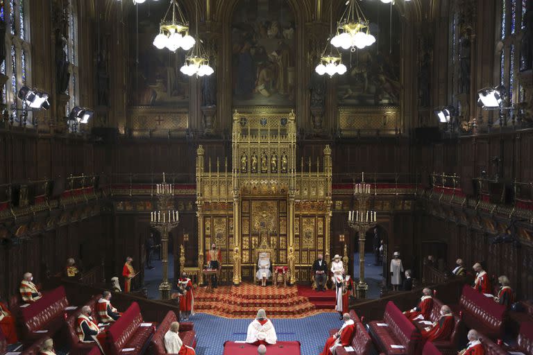 La reina Isabel II de Gran Bretaña (centro), acompañada del príncipe Carlos y Camilla, duquesa de Cornualles (derecha), pronuncia un discurso en la Cámara de los Lores, el martes 11 de mayo de 2021, en el Palacio de Westminster en Londres