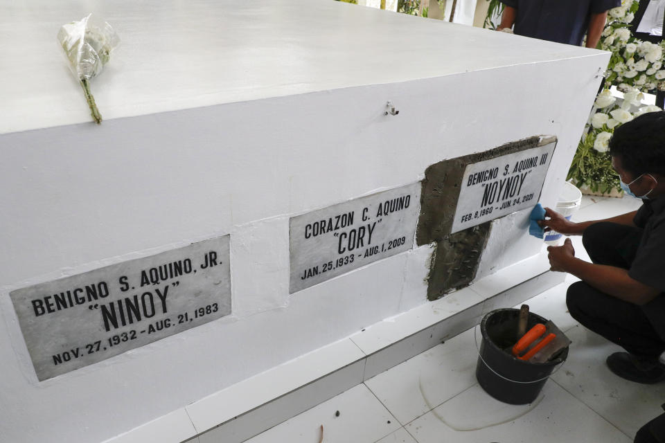 A worker puts on the cement on the tomb of former Philippine President Benigno Aquino III beside his parents during state burial rites on Saturday, June 26, 2021 at a memorial park in suburban Paranaque city, Philippines. Aquino was buried in austere state rites during the pandemic Saturday with many remembering him for standing up to China over territorial disputes, striking a peace deal with Muslim guerrillas and defending democracy in a Southeast Asian nation where his parents helped topple a dictator. He was 61. (AP Photo/Aaron Favila)