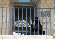 A woman displaced by the fighting in the Red Sea port city of Hodeidah sits behind a fence at a school allocated for IDPs in Sanaa, Yemen. REUTERS/Khaled Abdullah