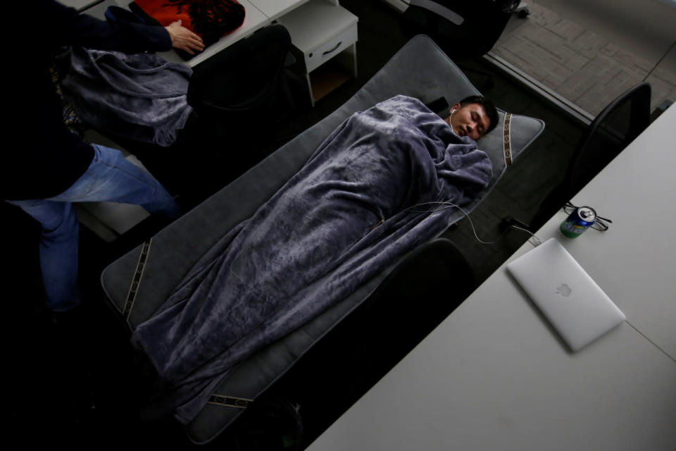 Han Liqun, an HR manager of RenRen Credit Management Co. in Beijing, sleeps on a camp bed at the office after finishing work early in the morning on April 27, 2016. (Jason Lee/Reuters)