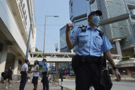 Police officers walk outside a court as they wait for Tong Ying-kit's arrival at a court in Hong Kong Tuesday, July 27, 2021. Hong Kong High Court will deliver verdict in the afternoon for the first person charged under Hong Kong's National Security Law. Tong was arrested in July 2020 after driving his motorbike into a group of police officers while carrying a flag bearing the protest slogan “Liberate Hong Kong." He was charged with inciting separatism and terrorism. (AP Photo/Vincent Yu)