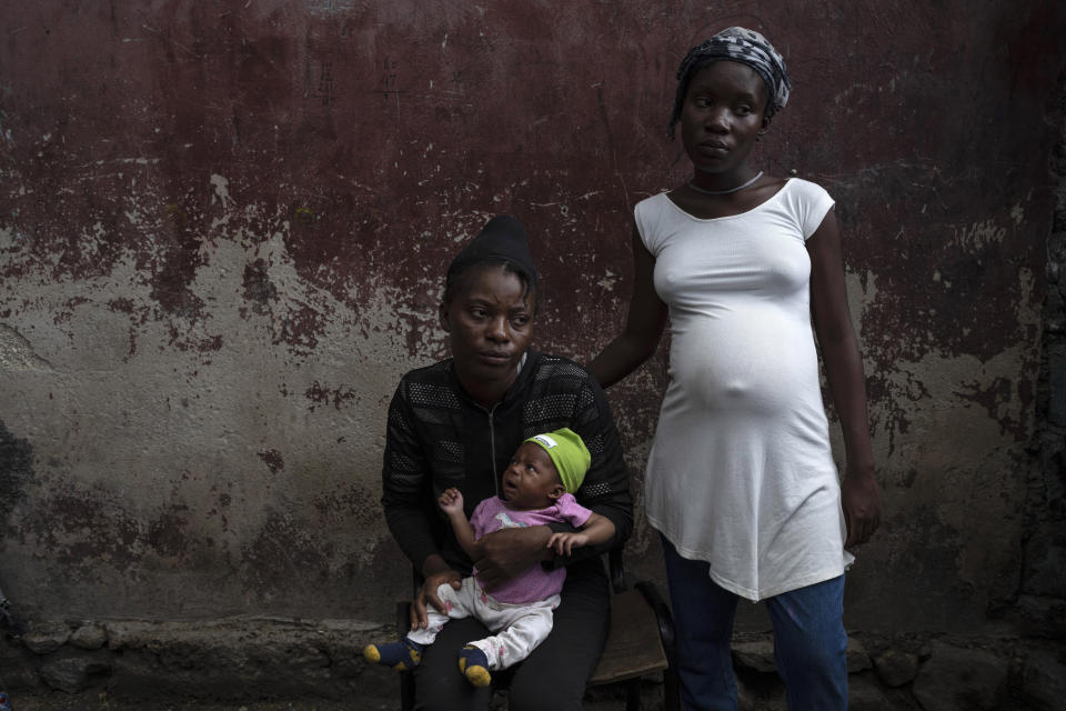 Januelle Datka, her baby girl Princess and her 15-year-old daughter Titti, pose for a photo at a makeshift shelter in Jean-Kere Almicar's front yard, in Port-au-Prince, Haiti, Sunday, June 4, 2023. Both mother and daughter said they were raped by gang members and that both became pregnant. (AP Photo/Ariana Cubillos)