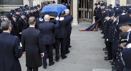 Pall bearers carry the coffin of PC Keith Palmer, the officer killed in the Westminster attack, into Southwark Cathedral for his funeral, in central London, Britain April 10, 2017. REUTERS/Frank Augstein/Pool