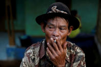 <p>A street vendor smokes a cigarette as he waits for customers in Cikawao village of Majalaya, West Java province, Indonesia, Oct. 12, 2017. (Photo: Beawiharta/Reuters) </p>