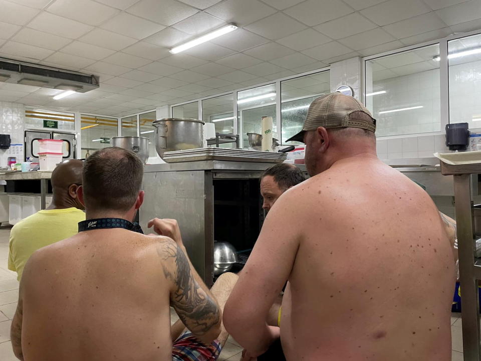 Hotel guests hide in a kitchen after shots were fired at a hotel in the beach resort of Cancun, Mexico.