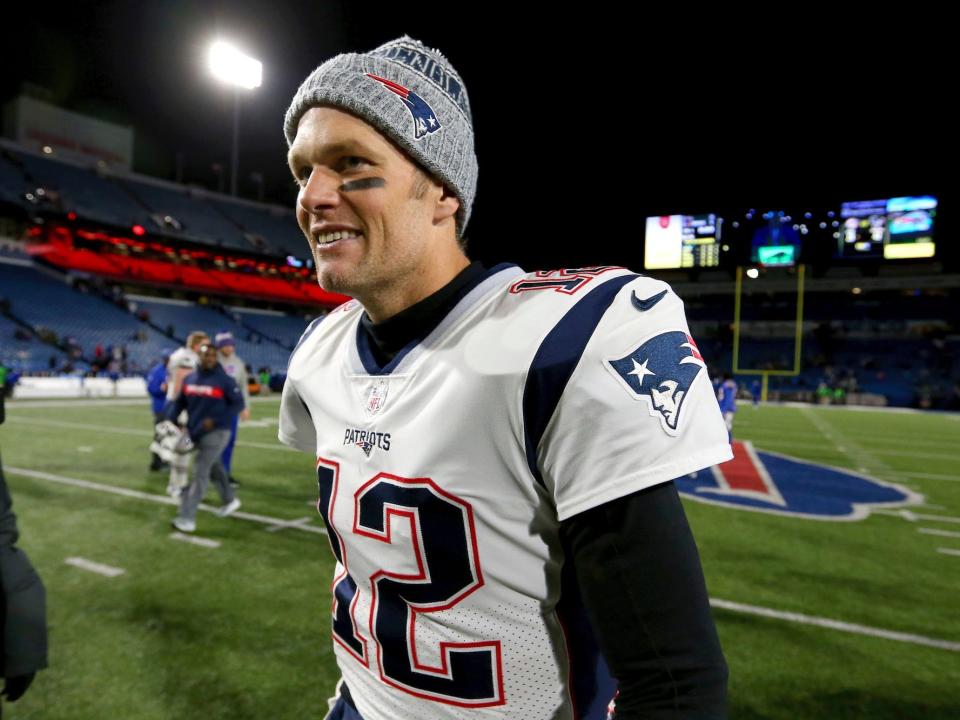 Tom Brady smiles as he walks off the field against the Bills in 2018.