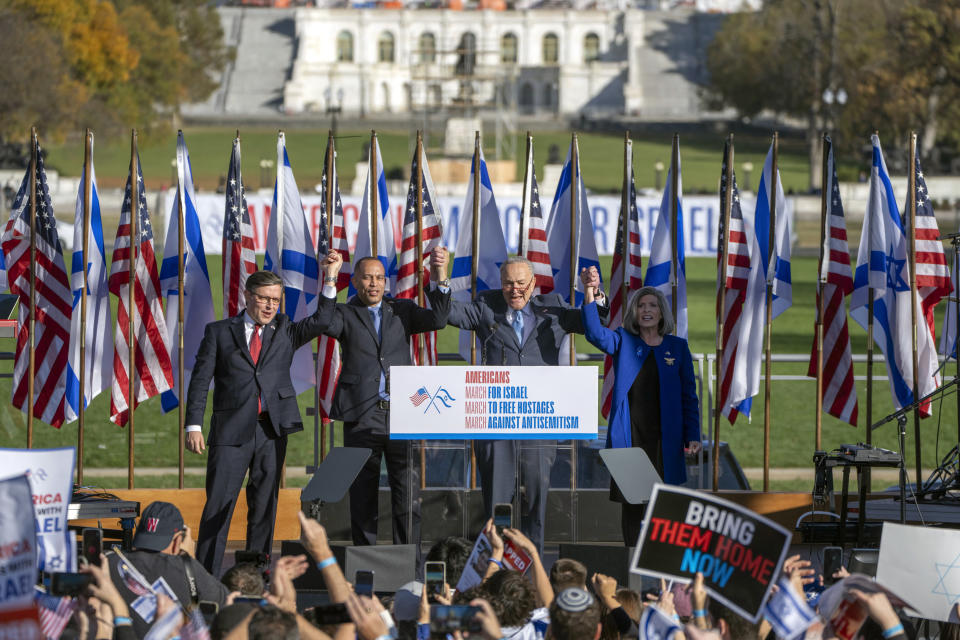 From left, Speaker of the House Mike Johnson of La., left, House Minority Leader Hakeem Jeffries of N.Y., Senate Majority Leader Chuck Schumer of N.Y., and Sen. Joni Ernst, R-Iowa, right, join hands at the March for Israel on Tuesday, Nov. 14, 2023, on the National Mall in Washington. (AP Photo/Mark Schiefelbein)
