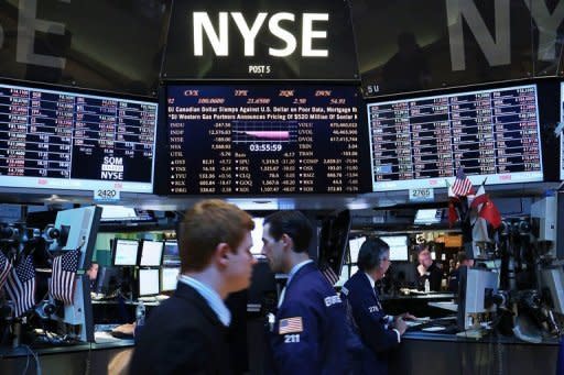 Traders work on the floor of the New York Stock Exchange. World stock markets mostly fell on Friday after the economic outlook in Germany soured sharply, with bank shares in focus after Moody's downgraded some of the biggest names including HSBC