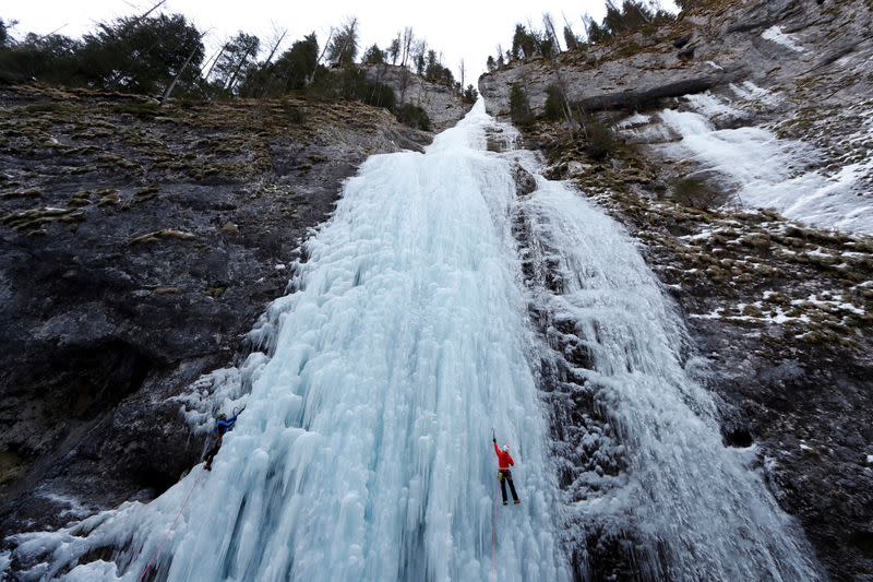 Italian alpine rescuers climb a frozen waterfall in Malga Ciapela