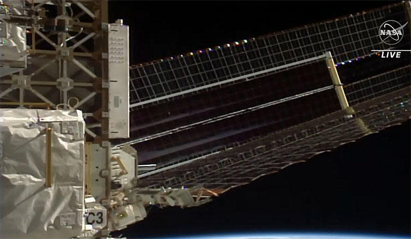 The newly installed iROSA blanket stretches out 60 feet in front of an existing solar wing on the far left side of the International Space Station's power truss. While smaller than the originals, the new arrays are more efficient. Working in concert with the existing arrays, the new panels will boost power output back to factory fresh levels. / Credit: NASA TV