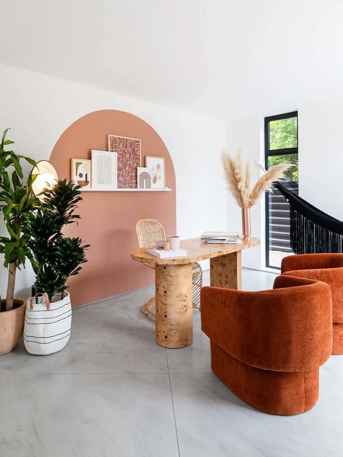 Contemporary living room adorned with rounded furniture pieces and arch shapes painted on the back wall.