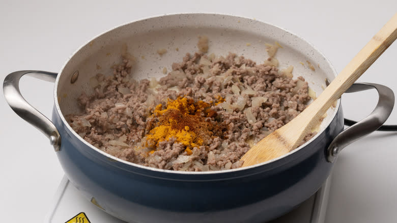 adding spices to ground lamb