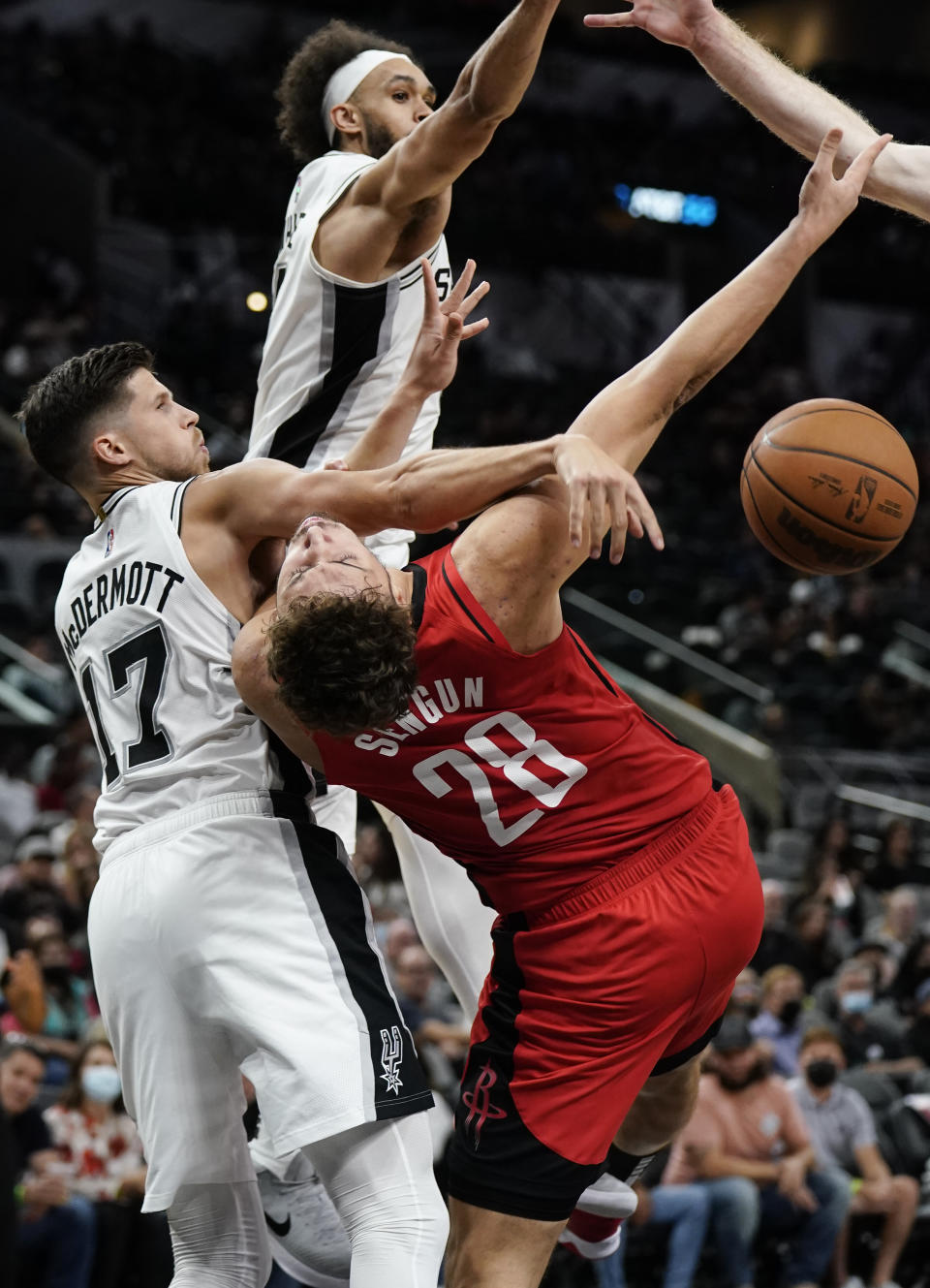 Houston Rockets' Alperen Sengun (28) is closely defended by San Antonio Spurs' Doug McDermott (17) and Derrick White during the first half of a preseason NBA basketball game, Friday, Oct. 15, 2021, in San Antonio. (AP Photo/Darren Abate)