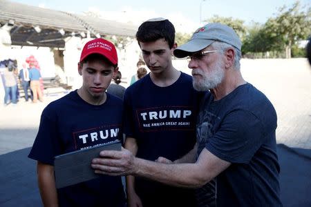 Israeli American Sruly Cooper(R) signs to vote in the US elections in front of members of the U.S. Republican party's election campaign team in Israel during a campaign aimed at potential American voters living in Israel, near a mall in Modi'in, Israel August 15, 2016. REUTERS/Baz Ratner