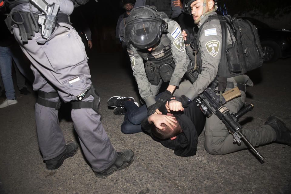 A Palestinian youth is pinned down by Israeli police after he was detained at a protest against the forcible eviction of Palestinian families from their homes in the Sheikh Jarrah neighborhood of Jerusalem, Thursday, May 6, 2021. Palestinians and Israeli settlers hurled rocks and chairs at each other in Sheikh Jarrah, where dozens of Palestinians are at risk of being evicted following a long legal battle with Jewish settlers trying to acquire property in the neighborhood, which is just north of Jerusalem's Old City. (AP Photo/Maya Alleruzzo)