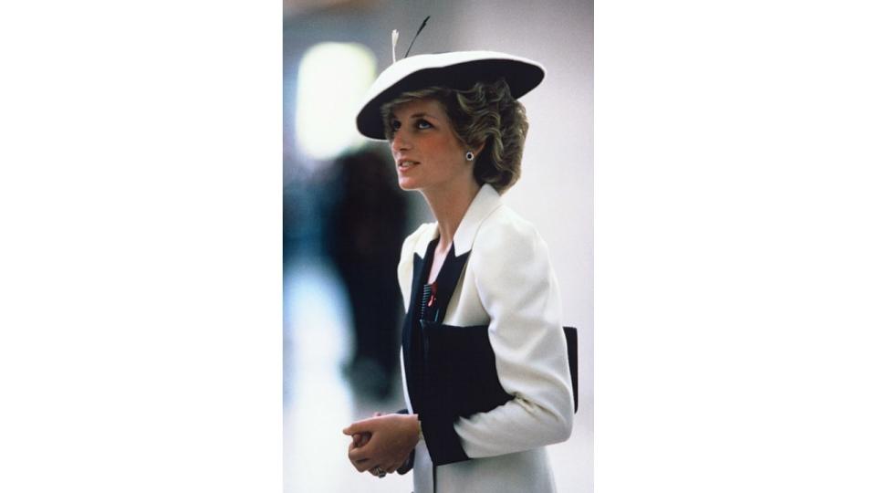 Diana in black and white suit and hat side profile