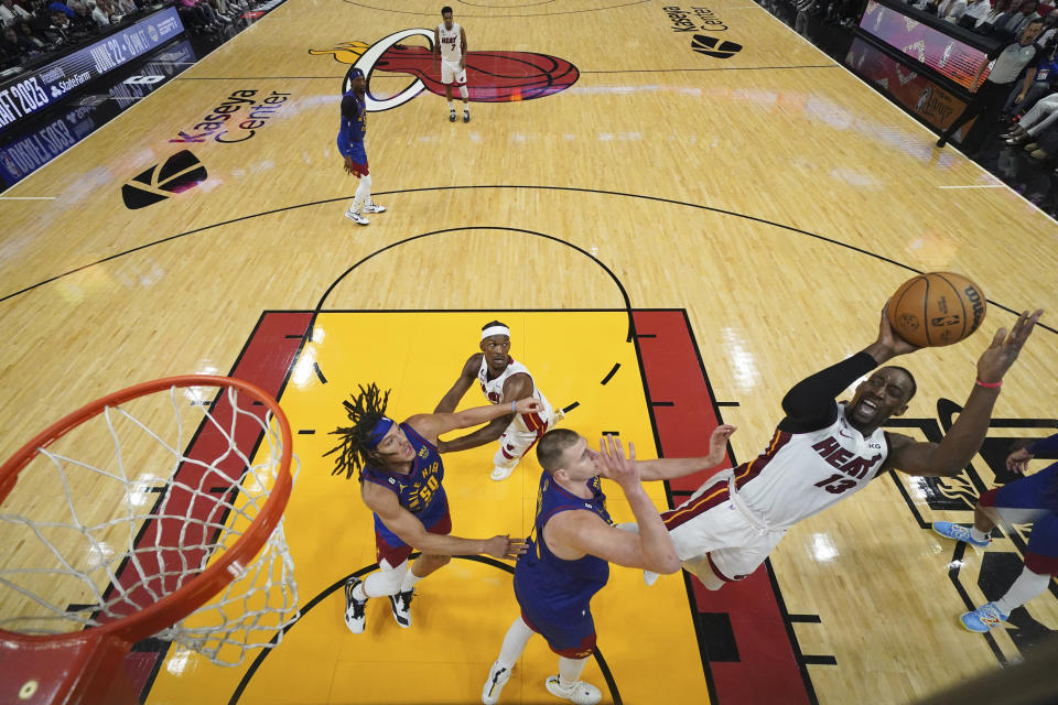 Miami Heat center Bam Adebayo (13) shoots against Denver Nuggets center Nikola Jokic, center, during the second half of Game 3 of basketball's NBA Finals, Wednesday, June 7, 2023, in Miami. (Kyle Terada/Pool Photo via AP)