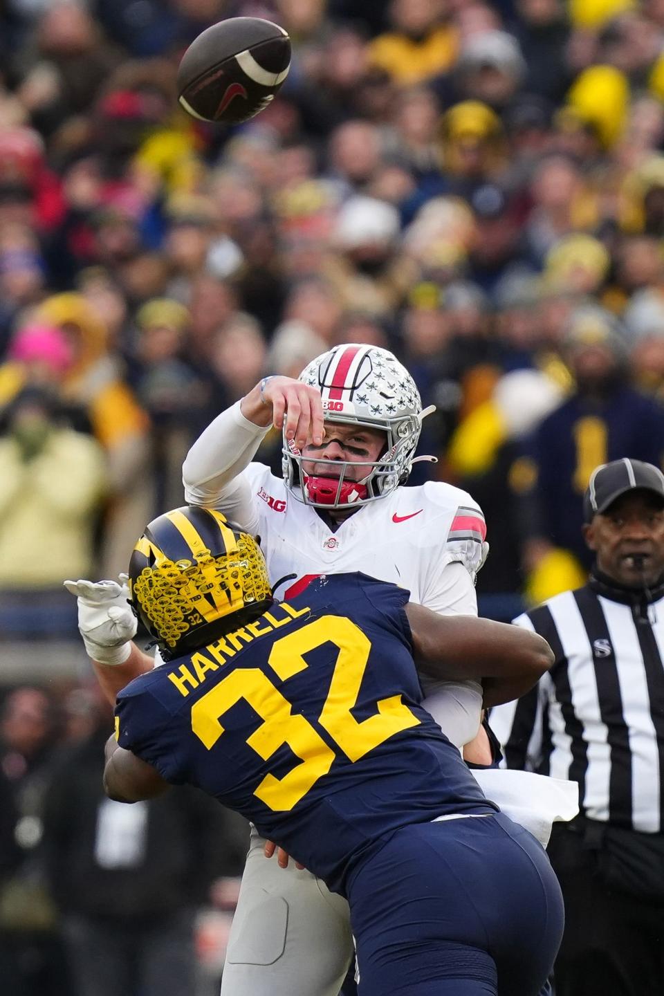 Nov 25, 2023; Ann Arbor, Michigan, USA; Ohio State Buckeyes quarterback Kyle McCord (6) is hit by Michigan Wolverines defensive end Jaylen Harrell (32) as he throws an interception during the second half of the NCAA football game at Michigan Stadium. Ohio State lost 30-24.