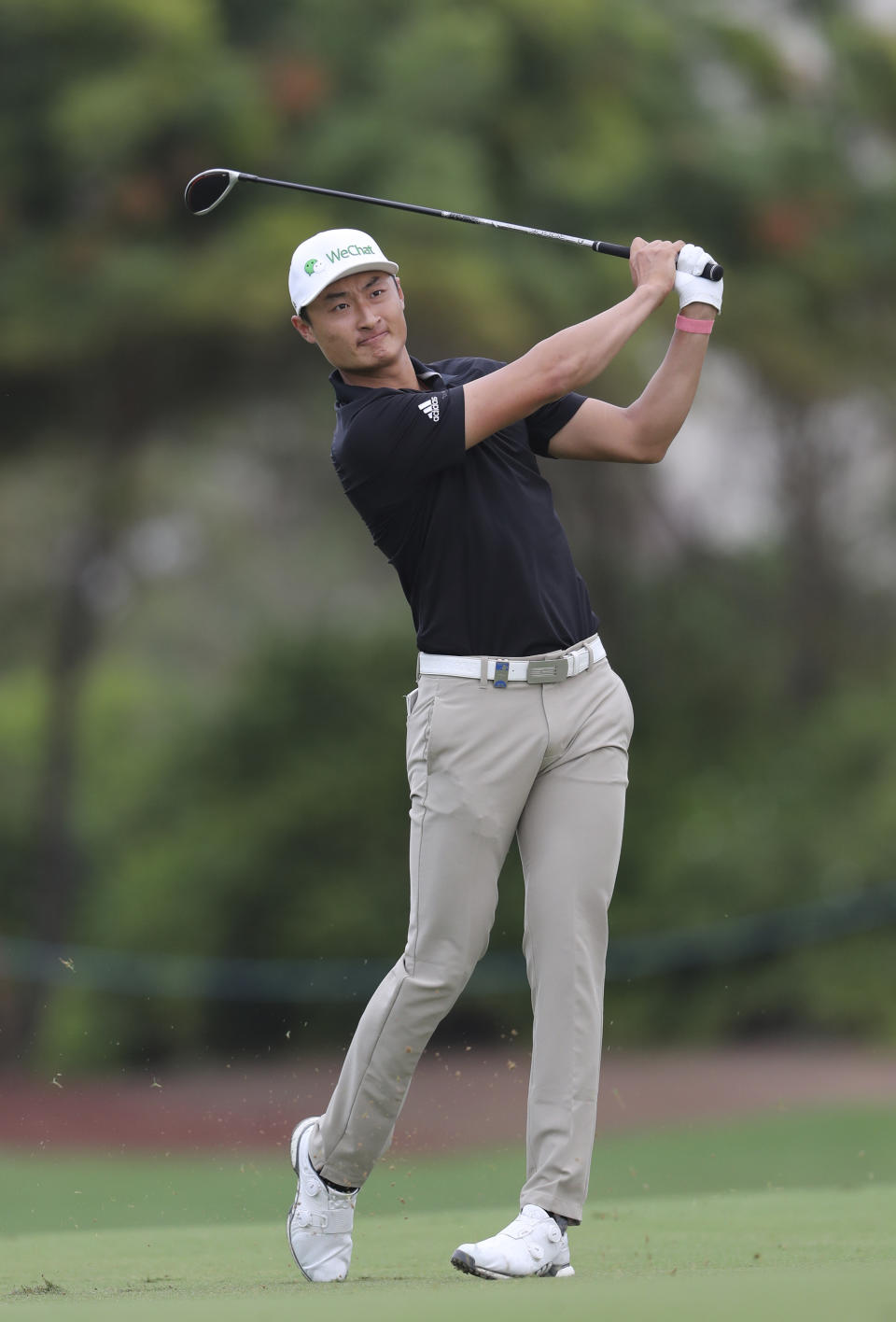 Haotong Li of China plays a shot on the 2nd hole during the first round of the DP World Tour Championship golf tournament in Dubai, United Arab Emirates, Thursday, Nov. 21, 2019. (AP Photo/Kamran Jebreili)