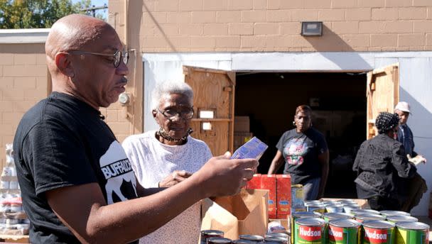 PHOTO: Darius Pridgen, pastor of the True Bethel Baptist Church in Buffalo, New York, helps volunteers from his church's food pantry, pass out free bags of groceries to local residents on Oct. 5, 2022. (Alysha Webb/ABC News)