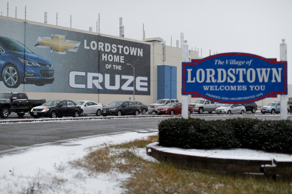 FILE - In this Nov. 27, 2018, file photo, a banner depicting the Chevrolet Cruze model vehicle is displayed at the General Motors' Lordstown plant, in Lordstown, Ohio. GM employees in Lordstown and other factories in Michigan and Maryland that are targeted to close within a year say moving will force them to leave behind relatives, even their children, in some cases.