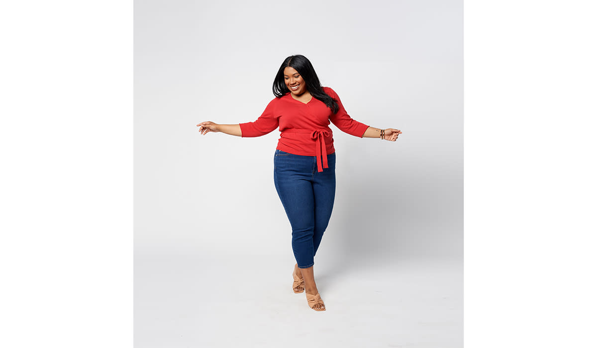 Woman wearing red wrap cardigan with jeans and heels