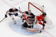 Chicago Blackhawks' Kirby Dach (77) flies past Edmonton Oilers' Caleb Jones (82) and goaltender Mikko Koskinen (19) during the second period of an NHL hockey playoff game Wednesday, Aug. 5, 2020, in Edmonton, Alberta. (Codie McLachlan/The Canadian Press via AP)