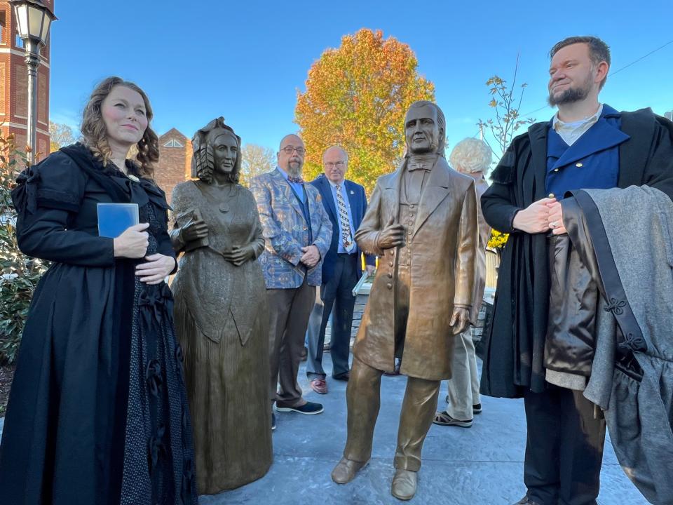 Reenactors dressed as James K. Polk and his wife Sarah Polk stand with life-size statues of the former President and First Lady at the new Polks at Preservation Park off West. 7th Street across from the James K. Polk Home & Museum.