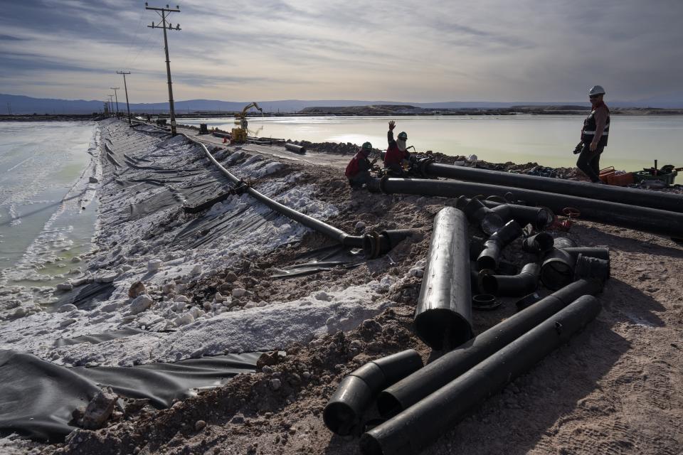 Workers perform maintenance next to pools of brine slowly turning into lithium at the SQM mine in Chile's Atacama desert, Tuesday, April 18, 2023. (AP Photo/Rodrigo Abd)