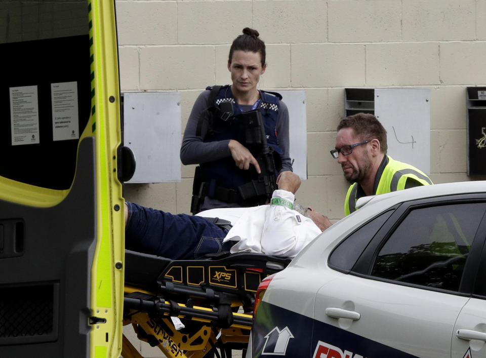 An armed police officer watches as a man is taken by ambulance staff from a mosque in central Christchurch, New Zealand, March 15, 2019. (Photo: Mark Baker/AP)