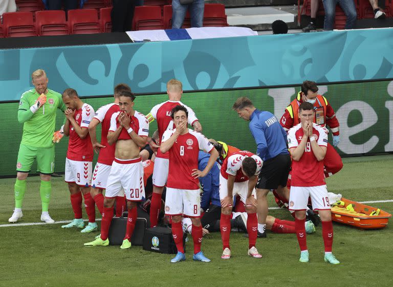 Los jugadores de Dinamarca reaccionan cuando su compañero de equipo Christian Eriksen yace en el suelo durante el partido del grupo B del campeonato de fútbol de la Eurocopa 2020 entre Dinamarca y Finlandia en el estadio Parken en Copenhague